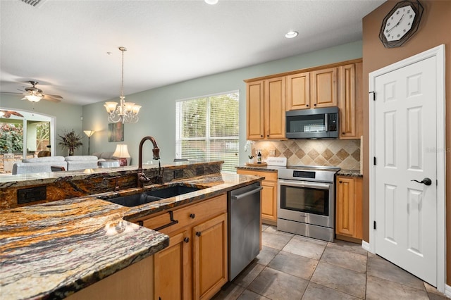 kitchen with a wealth of natural light, tasteful backsplash, appliances with stainless steel finishes, and a sink