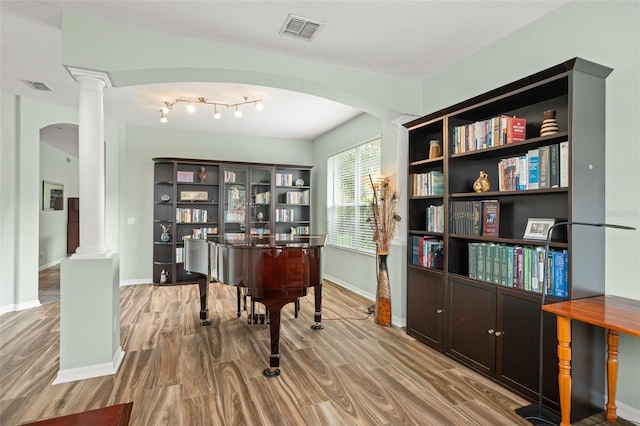 sitting room with visible vents, wood finished floors, decorative columns, and baseboards