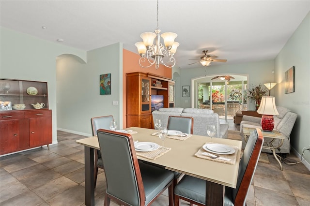 dining space with arched walkways, baseboards, and ceiling fan with notable chandelier