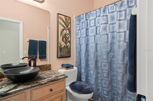 bathroom with curtained shower, vanity, and toilet