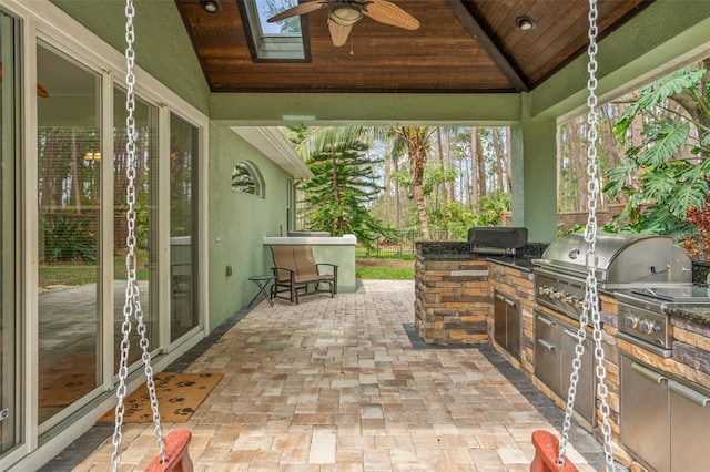 view of patio / terrace with a gazebo, an outdoor kitchen, a grill, and a ceiling fan