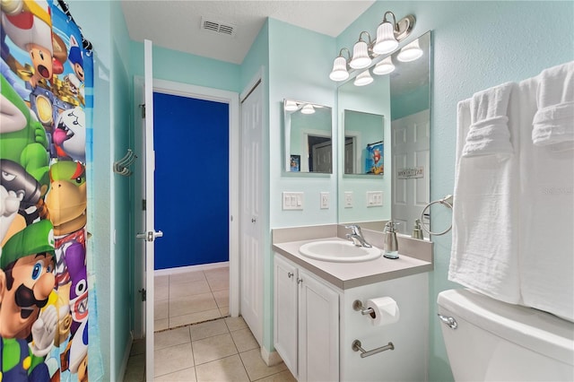 bathroom featuring visible vents, vanity, toilet, and tile patterned floors