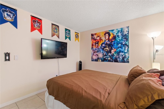 bedroom featuring light tile patterned floors, a textured ceiling, and baseboards