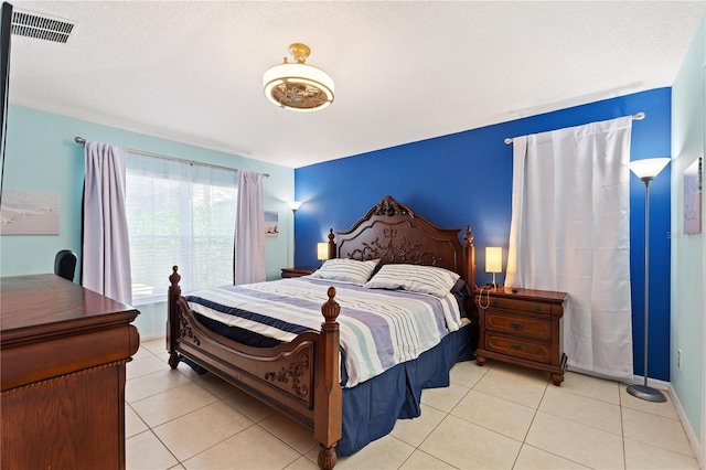 bedroom featuring baseboards, visible vents, and tile patterned floors