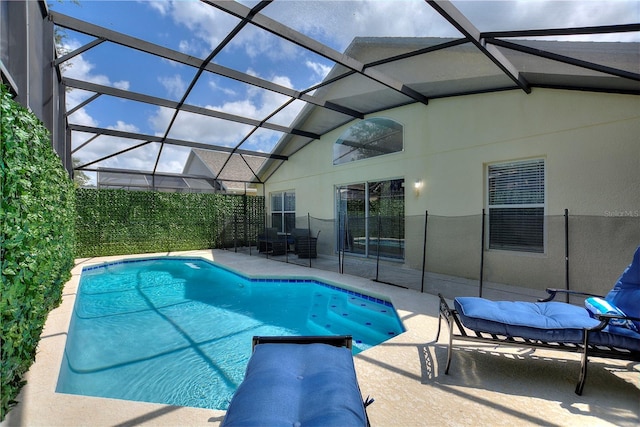 view of pool with a fenced in pool, glass enclosure, and a patio area