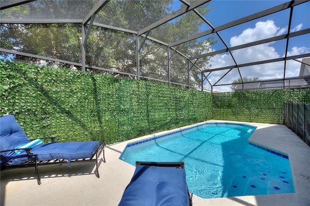 view of swimming pool with a lanai, a patio area, fence, and a fenced in pool