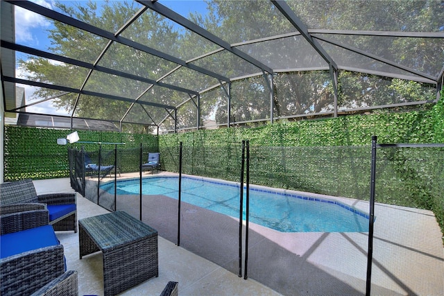 view of swimming pool featuring glass enclosure, fence, a fenced in pool, and a patio