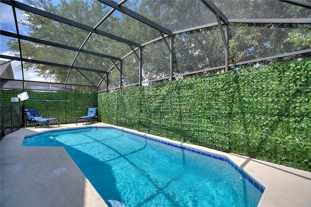 view of pool featuring glass enclosure, a patio area, fence, and a fenced in pool