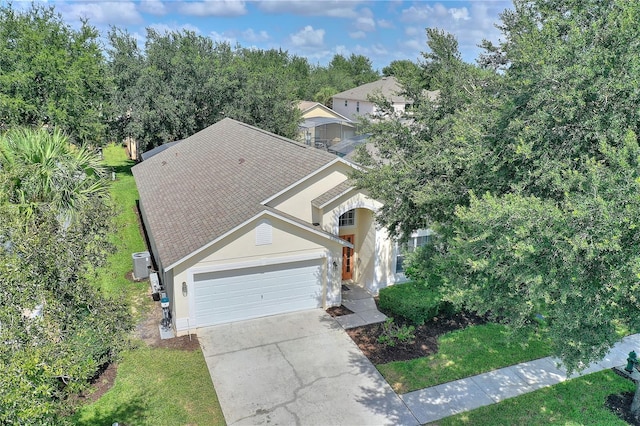 view of front of house featuring an attached garage, a front yard, concrete driveway, and stucco siding