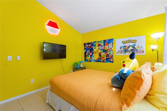 tiled bedroom with vaulted ceiling and baseboards