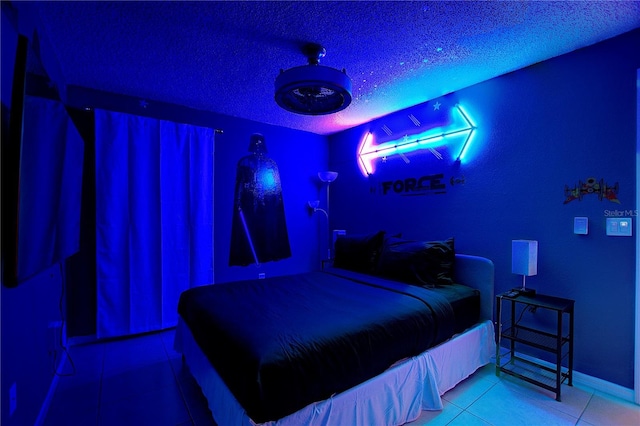 bedroom featuring a textured ceiling, tile patterned flooring, and baseboards