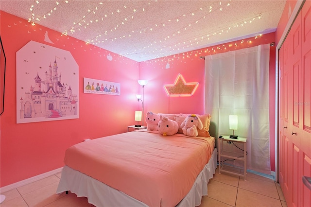 bedroom with a closet, baseboards, and light tile patterned floors