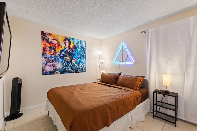 bedroom featuring baseboards, a textured ceiling, and light tile patterned flooring