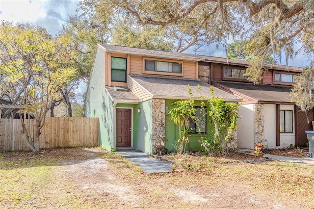 view of front of house featuring a shingled roof and fence