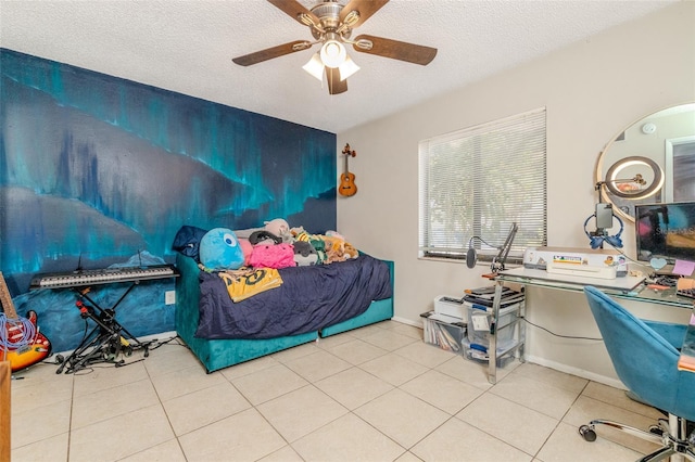 tiled bedroom with a textured ceiling, ceiling fan, and baseboards