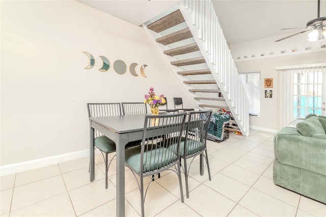 dining space featuring ceiling fan, stairway, light tile patterned flooring, and baseboards