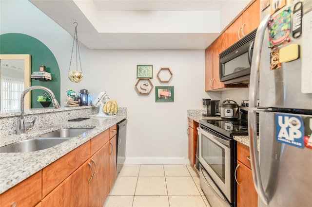 kitchen featuring appliances with stainless steel finishes, brown cabinetry, and a sink