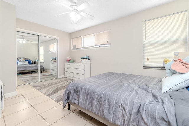 bedroom featuring light tile patterned floors, ceiling fan, and a closet