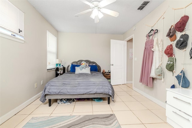 bedroom featuring light tile patterned floors, baseboards, visible vents, and a ceiling fan