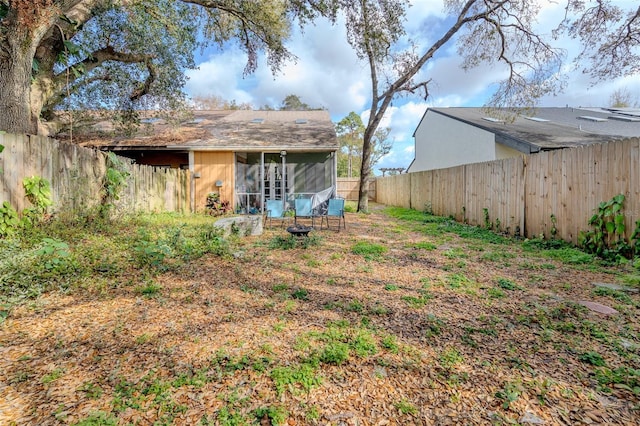 view of yard featuring a sunroom and a fenced backyard