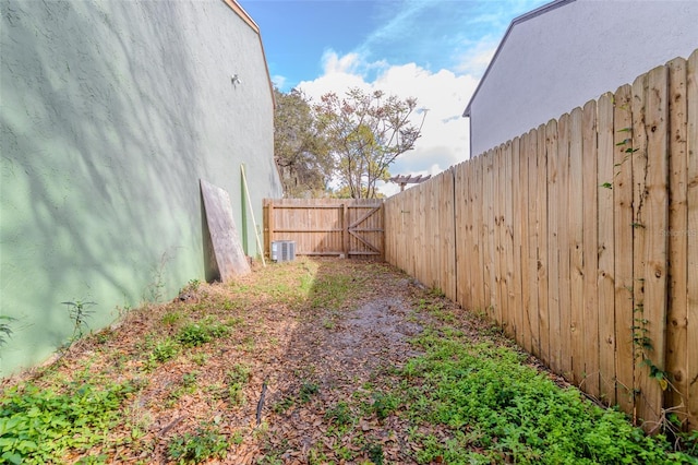 view of yard featuring fence and central AC unit