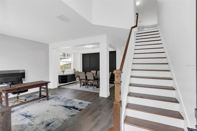 stairway featuring visible vents, baseboards, and wood finished floors