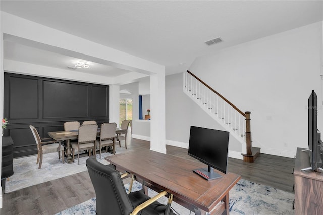 office area featuring baseboards, visible vents, and wood finished floors