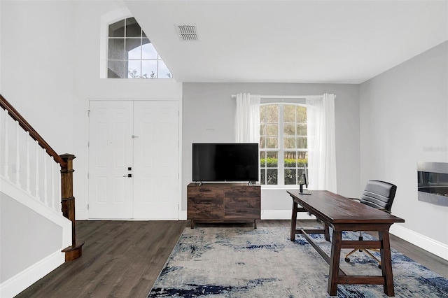 office space with baseboards, visible vents, and wood finished floors