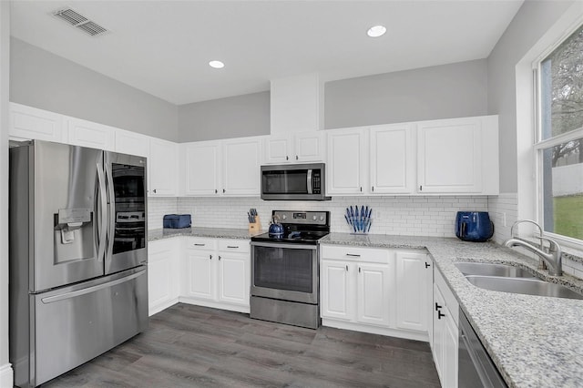 kitchen featuring stainless steel appliances, a sink, visible vents, and a healthy amount of sunlight