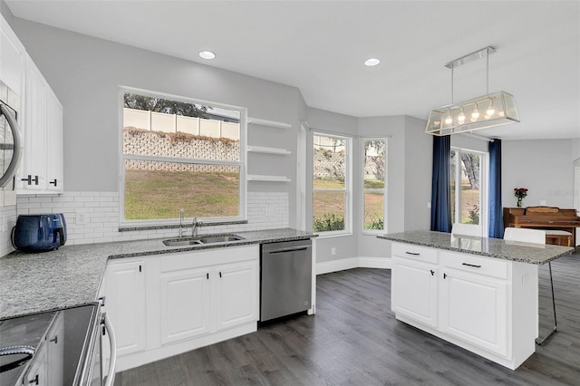 kitchen with light stone counters, dark wood finished floors, decorative backsplash, a sink, and dishwasher