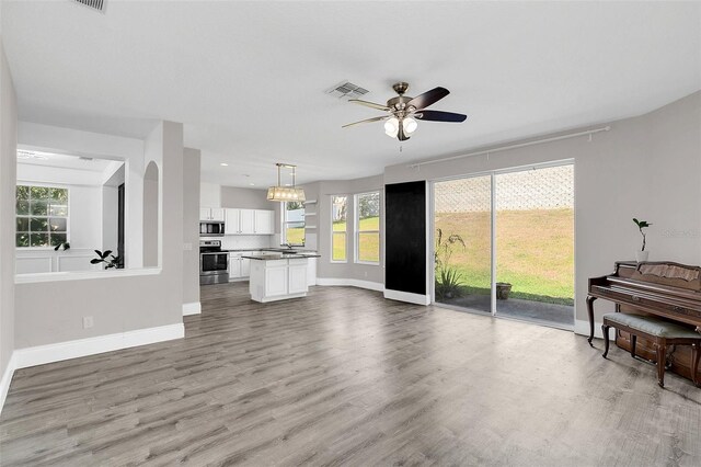 living room with baseboards, visible vents, ceiling fan, wood finished floors, and recessed lighting