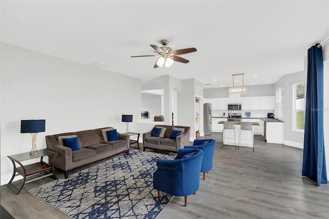 living room featuring recessed lighting, ceiling fan, baseboards, and wood finished floors