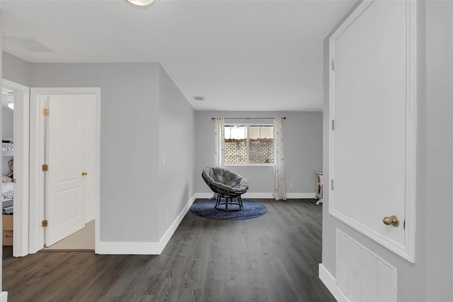 unfurnished room featuring baseboards, visible vents, and wood finished floors