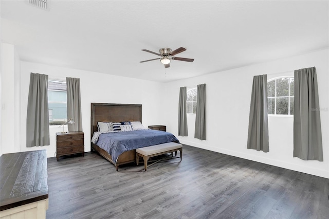 bedroom with a ceiling fan, multiple windows, visible vents, and wood finished floors