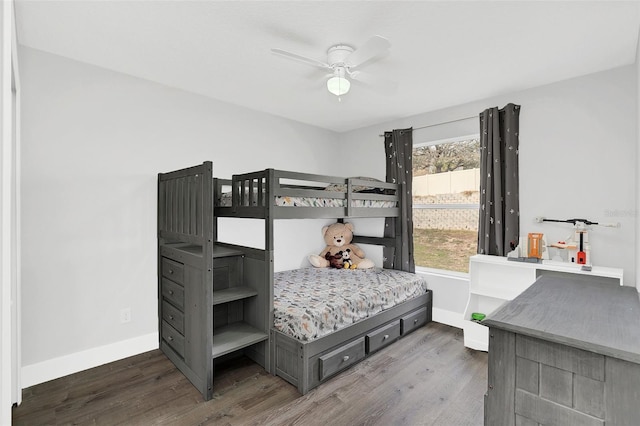 bedroom with ceiling fan, wood finished floors, and baseboards