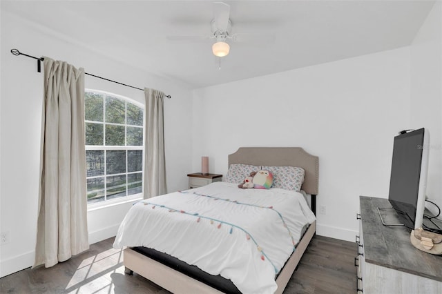 bedroom with a ceiling fan, baseboards, and dark wood-type flooring