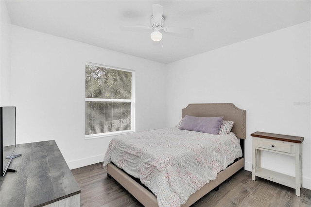 bedroom with ceiling fan, wood finished floors, and baseboards