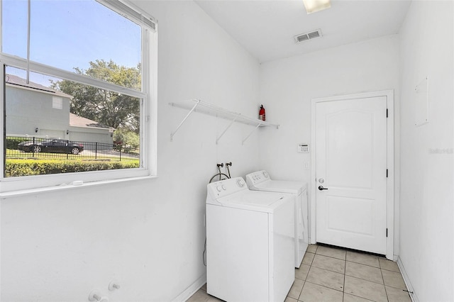 laundry room with washer and clothes dryer, light tile patterned floors, visible vents, laundry area, and baseboards