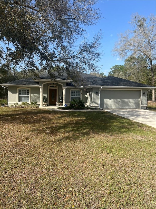 ranch-style home with an attached garage, stucco siding, concrete driveway, and a front yard