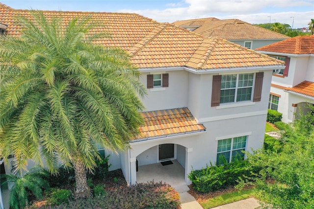 exterior space featuring a tile roof and stucco siding