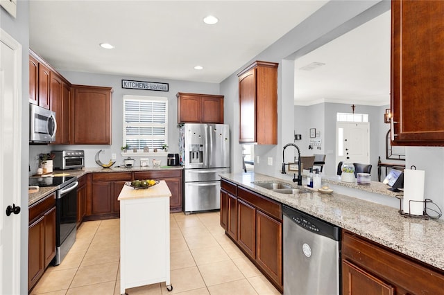 kitchen featuring light stone countertops, stainless steel appliances, a sink, and light tile patterned flooring