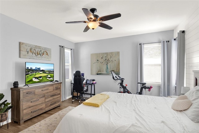 bedroom featuring wood finished floors, a ceiling fan, and baseboards