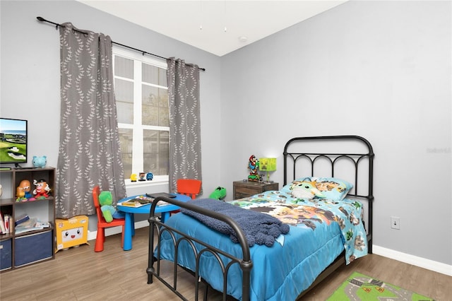 bedroom with baseboards and wood finished floors