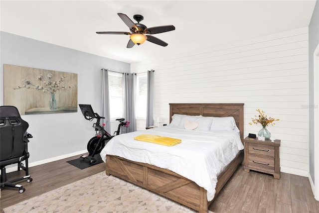 bedroom with a ceiling fan, baseboards, and wood finished floors