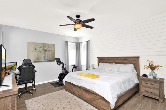 bedroom featuring a ceiling fan, baseboards, and wood finished floors