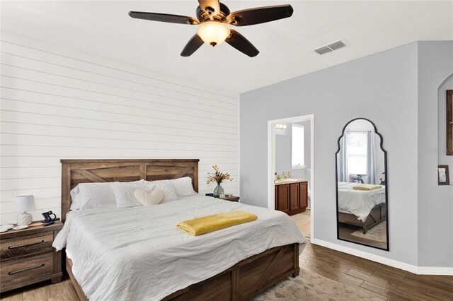 bedroom featuring visible vents, light wood-style floors, connected bathroom, ceiling fan, and baseboards