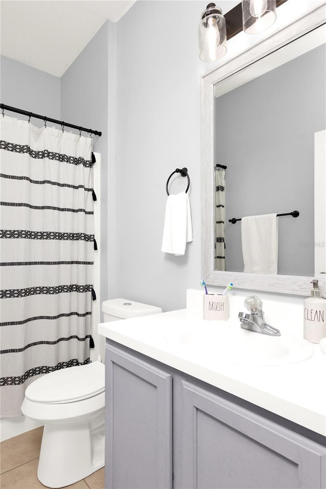 bathroom featuring curtained shower, vanity, toilet, and tile patterned floors