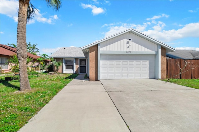 view of front facade with an attached garage, fence, concrete driveway, and brick siding