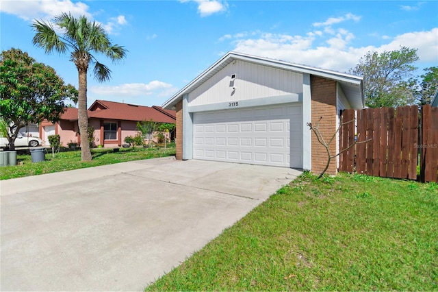 view of front of property with driveway, an attached garage, fence, a front lawn, and brick siding