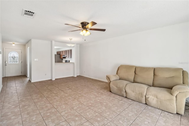 unfurnished living room with ceiling fan, visible vents, baseboards, and light tile patterned flooring